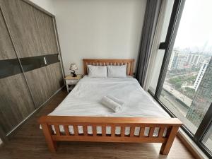 een bed in een kamer met een groot raam bij Lynn House Metropolis 2Bedrooms Cozy - nearLotte Daewoo in Hanoi