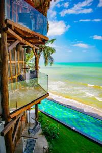 a view of the ocean from the balcony of a beach house at RCH LUXURY HOTEL & POOL in Dibulla