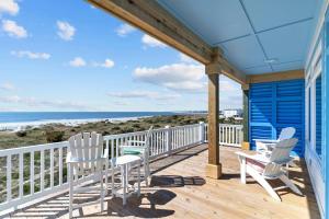 a deck with chairs and a table and a view of the ocean at SeaSons at the Point in Oak Island