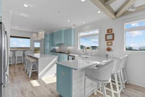 a kitchen with blue cabinets and white counter tops at SeaSons at the Point in Oak Island