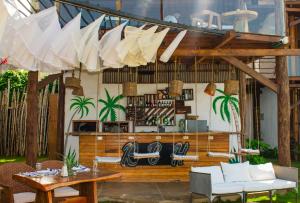 a patio with a table and chairs and umbrellas at Amāra Beach Eco Hotel in Dibulla +63 photos