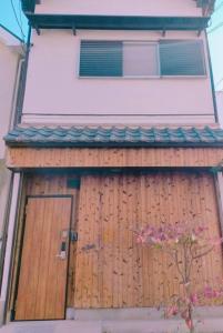 uma porta de madeira num edifício com uma janela em LILY's House em Sano