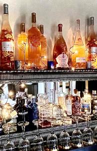 a shelf filled with lots of bottles and glasses at Gäste Residenz Happy Kitz in Kitzbühel