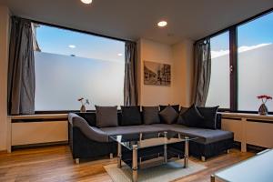 salon z kanapą i dużymi oknami w obiekcie Innsbruck City Apartment + 1 free parking spot w mieście Innsbruck