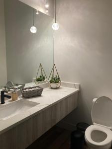 ケロウナにあるModern and cozy 4-Plex with a view! (1Bed, 1 Private Bathroom)の白いバスルーム(洗面台、トイレ付)