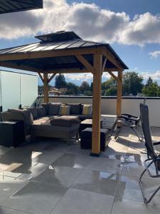 einen Pavillon mit einer Couch und einem Regenschirm auf dem Dach in der Unterkunft Modern and cozy 4-Plex with a view! (1Bed, 1 Private Bathroom) in Kelowna