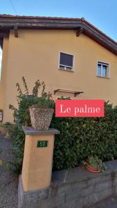 uma casa com um sinal que lê palma da mão em Le Palme em Monte Ceneri