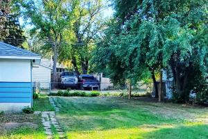 um quintal com dois carros estacionados numa garagem em TheAuroras: Vibrant&Cheerful 2 bdrm Stylish suite em Saskatoon