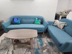 een woonkamer met een blauwe bank en een salontafel bij TheAuroras: Vibrant&Cheerful 2 bdrm Stylish suite in Saskatoon