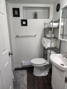 a white bathroom with a toilet and a sink at TheAuroras: Vibrant&Cheerful 2 bdrm Stylish suite in Saskatoon