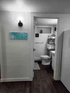a bathroom with a toilet and a sink and a door at TheAuroras: Vibrant&Cheerful 2 bdrm Stylish suite in Saskatoon