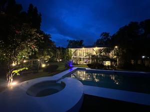 una piscina frente a un edificio por la noche en G-HOTEL LUXURY VILLA RESORT AND HOT SPRING en Calamba