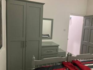 a bedroom with a dresser and a large mirror at Ihola's Nest in Carriacou