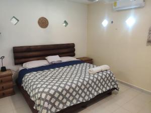 una camera con letto e testiera in legno di Corazón Abierto a Chicxulub