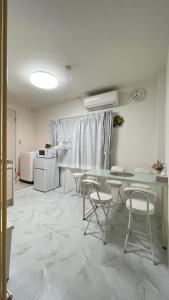 a room with a table and chairs and a kitchen at 幸・3 in Osaka