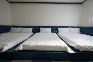 two beds sitting next to each other in a room at SloCruise in Gongju