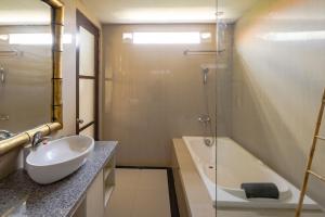 a bathroom with a sink and a glass shower at Canggu Spirit Guest House in Canggu