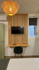 Pokój z krzesłem i telewizorem na ścianie w obiekcie DUPLEX 101 w Dzaoudzi
