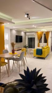 ein Wohnzimmer mit einem gelben Sofa, einem Tisch und Stühlen in der Unterkunft DUPLEX 101 in Dzaoudzi