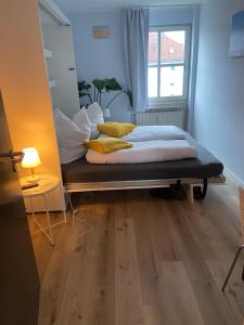 a bed with yellow pillows in a room with a window at Bayern Lodge München in Munich