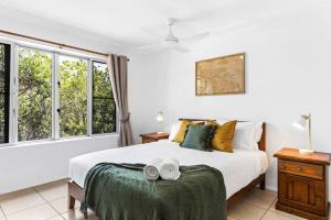 1 dormitorio con 1 cama blanca grande y ventanas en Twin Waters Seaside Resort Life, en Twin Waters