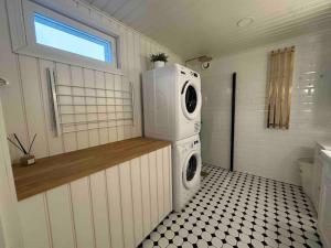 uma lavandaria com máquina de lavar e secar roupa em Koko talo & piha ulkopore-altaalla em Hanko