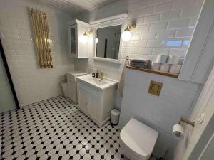 een witte badkamer met een toilet en een wastafel bij Koko talo & piha ulkopore-altaalla in Hanko