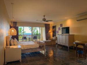 sypialnia z łóżkiem oraz salon z telewizorem w obiekcie Palm Beach Resort & SPA w mieście Labuan