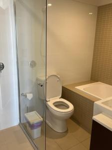 a bathroom with a toilet and a shower and a sink at Hurstville New apartment with city view in Sydney