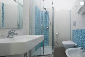 een badkamer met een wastafel, een douche en een toilet bij B&B Sempione in Cosenza