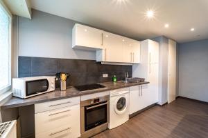 希爾蒂蓋姆的住宿－magnifique appartement F2，厨房配有白色橱柜和微波炉