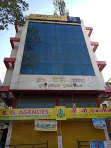 a tall building with a sign in front of it at Hotel Rahi,Nashik in Nashik