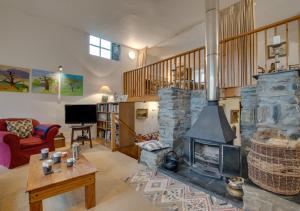 a living room with a large stone fireplace at Ty Capel Carmel in Llanfachreth
