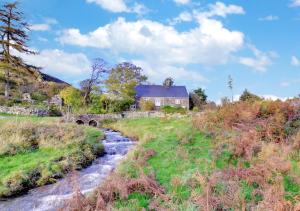 a house on a hill next to a stream at Ty Capel Carmel in Llanfachreth