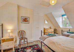 1 dormitorio con 2 camas, escritorio y silla en 3 St Mary's Villas en Hay-on-Wye