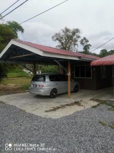 a car parked under a carport in a garage at LS ROMESTAY in Kangar