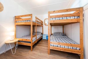two bunk beds in a room with a table and a lamp at Captains Retreat - Coastal Vibe in Lancelin