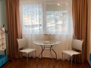 uma mesa e duas cadeiras em frente a uma janela em Green Gate Apartments em Sarajevo