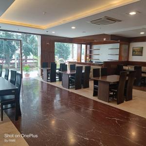ein Esszimmer mit Tischen und Stühlen in einem Gebäude in der Unterkunft ASTRA HOTELS & SUITES WHITEFIELD NEAR TO NALLURAHALLI METRO STATION and KTPO in Bangalore