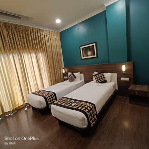 2 camas en una habitación de hotel con paredes azules en ASTRA HOTELS & SUITES WHITEFIELD NEAR TO NALLURAHALLI METRO STATION and KTPO en Bangalore