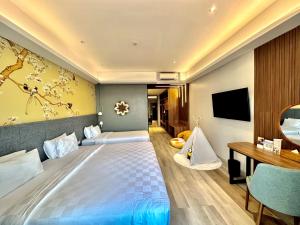 una camera d'albergo con un grande letto e una scrivania di Swiss-Belcourt Kupang a Oesapa-besar