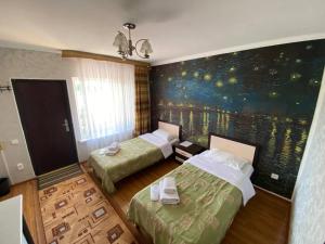 a room with two beds and a painting on the wall at Арт-отель ololoFamily in Chon-Sary-Oy