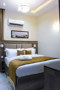 ein Schlafzimmer mit einem großen Bett in einem Zimmer in der Unterkunft Castle Estate APartments in Abuja