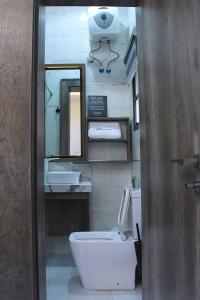 ein Badezimmer mit einem Waschbecken, einem WC und einem Spiegel in der Unterkunft Castle Estate APartments in Abuja