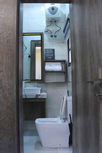 a bathroom with a sink and a toilet and a mirror at Castle Estate APartments in Abuja