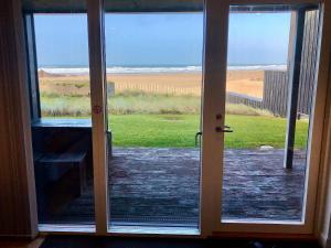 an open door with a view of the beach at Chapel Rock View, The Dunes in Perranporth