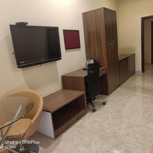 Zimmer mit einem TV, einem Schreibtisch und einem Stuhl in der Unterkunft ASTRA HOTELS & SUITES WHITEFIELD NEAR TO NALLURAHALLI METRO STATION and KTPO in Bangalore