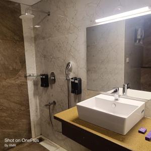 ein Badezimmer mit einem weißen Waschbecken und einem Spiegel in der Unterkunft ASTRA HOTELS & SUITES WHITEFIELD NEAR TO NALLURAHALLI METRO STATION and KTPO in Bangalore