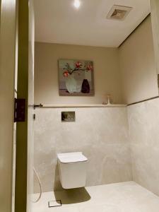 ein Bad mit einem WC und einem Wandgemälde in der Unterkunft فيلا بمسبح وحديقة خاصة in Al-'Ula