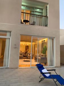 une chaise bleue assise devant une maison dans l'établissement فيلا بمسبح وحديقة خاصة, à Al-Ula